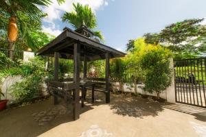 a picnic shelter with two benches in front of a fence at Bella Homes 6BR 4Bath near Rotunda in Tagaytay