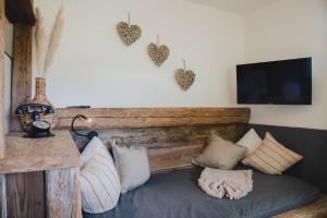 Habitación con sofá con almohadas y TV. en Landhaus Theresia, en Maria Alm am Steinernen Meer