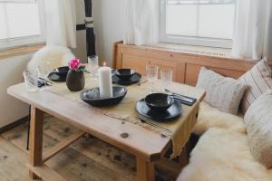 una mesa de madera con platos y velas en un sofá en Landhaus Theresia, en Maria Alm am Steinernen Meer