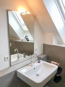 bagno con lavandino e specchio di Seebox Appartment 6 a Norderney