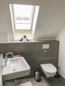 bagno con lavandino, servizi igienici e finestra di Seebox Appartment 6 a Norderney