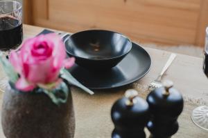 una mesa con un tazón negro y una rosa rosa en Landhaus Theresia, en Maria Alm am Steinernen Meer