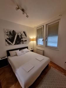 una camera con un letto bianco e due finestre di Apartman Veselinovic Free PARKING a Vranje