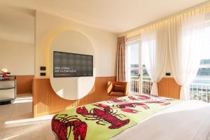 a bedroom with a bed and a tv on a wall at Hotel Grand Koper in Koper