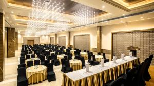 une salle de banquet avec des tables et des chaises ainsi qu'un podium dans l'établissement The Monarch Hotel & Convention Centre, à Trivandrum