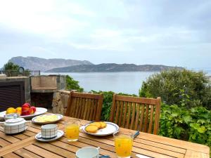 een houten tafel met borden met eten en drinken erop bij SAN TEODORO PUNTA EST SPETTACOLARE QUADRILOCALE VISTA MARE in Capo Coda Cavallo