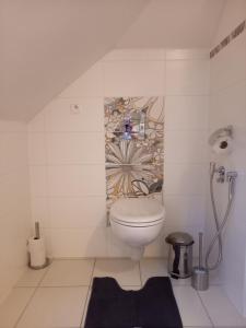 a bathroom with a toilet and a flower on the wall at apartmány LUHA in Luhačovice