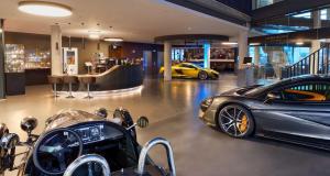 - une salle d'exposition de voitures de luxe avec 2 voitures garées à l'intérieur dans l'établissement V8 HOTEL Motorworld Region Stuttgart, à Böblingen