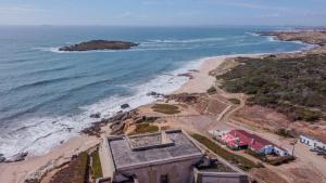 een luchtzicht op een strand met een huis en de oceaan bij Hotel Dom Vasco in Sines