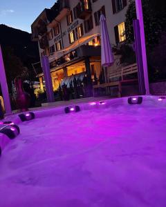 een hot tub met paarse verlichting voor een gebouw bij DU GLACIER Boutique & Traditions Hotel in Fiesch