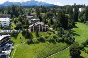 una vista aérea de una gran casa en un campo verde en T3 Hotel Mira Val, en Flims