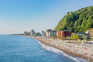 a beach with umbrellas and people on the beach at Resort In Gonio in Kvariati