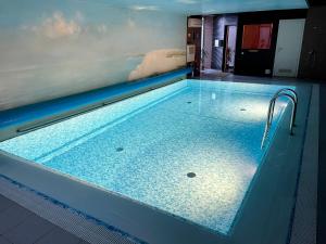 a large swimming pool with a blue tile floor at Nidos kempingas in Nida