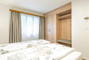 una camera con letto e finestra di Lauberhorn Apartment - Aare Jungfrau AG a Grindelwald