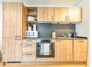 una cucina con armadi in legno e piano cottura di Lauberhorn Apartment - Aare Jungfrau AG a Grindelwald