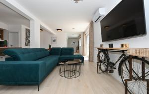 a living room with a blue couch and a bike at Luxury Apartment Maravic with Private Pool in Trogir