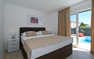 a bedroom with a large bed and a large window at Luxury Apartment Maravic with Private Pool in Trogir