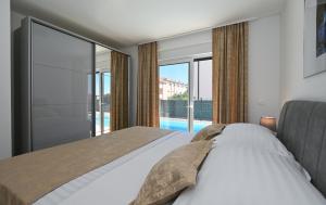 a bedroom with a bed and a large window at Luxury Apartment Maravic with Private Pool in Trogir