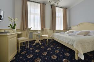 a bedroom with a bed and a table and chairs at Hotel Podhrad in Hluboká nad Vltavou