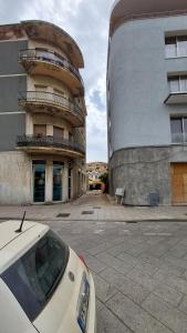 un coche blanco estacionado frente a un edificio en B&B Sa Cannacca, en Olbia