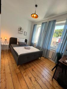 1 dormitorio con 1 cama y suelo de madera en O&W Ferienhaus mit Pool nähe Nürburgring, Adenau, en Adenau