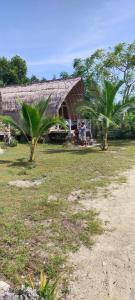 una casa con due palme di fronte di Alam Karang a Gili Gede