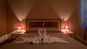 una camera con un letto con due asciugamani e due lampade di C Comfort Hotel & Wellness a Hisarya