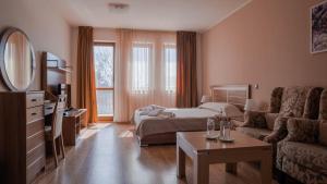 un soggiorno con letto e divano di C Comfort Hotel & Wellness a Hisarya