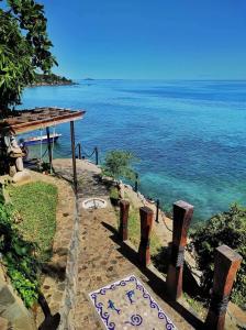 un chemin menant à l'océan avec un panneau. dans l'établissement Villa Nautilus, à Nosy Komba