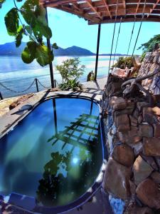 un étang dans un mur en pierre avec vue sur l'eau dans l'établissement Villa Nautilus, à Nosy Komba