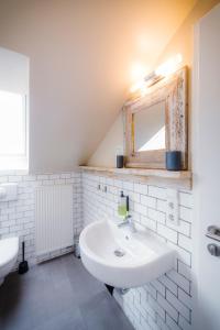 a white bathroom with a sink and a mirror at Hotel Luis in Regensburg