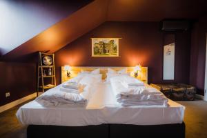 a large bed with white sheets and pillows in a bedroom at Hotel Luis in Regensburg