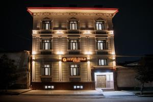 a tall building with lights on it at night at Guest House Diyor Gold in Samarkand