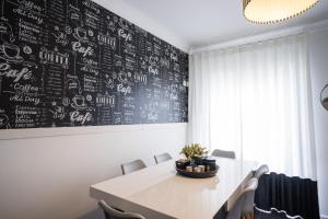 a dining room with a white table and a blackboard at Casa "Vó Minda" - Nazaré - Alojamento Local in Nazaré