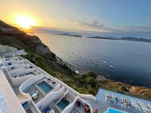 a view of the ocean and a beach at sunset at Kokkinos Villas in Akrotiri