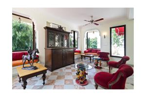 - un salon avec des meubles rouges et une statue de cheval dans l'établissement Dera Rawatsar - Heritage Hotel, à Jaipur