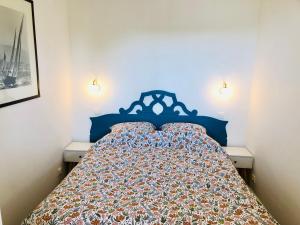 un letto con testiera blu in una camera da letto di Bel appartement cosy en résidence avec piscine a Deauville