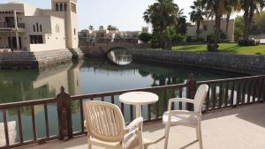 uma mesa e duas cadeiras numa varanda com um rio em Peaceful Private Villa at Five Star Beach Resort em Ras al-Khaimah