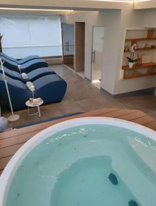 a large swimming pool in a room with a couch at Almalux Jesolo Wellness & Spa 3 stelle superior in Lido di Jesolo