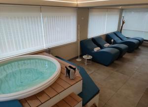 a living room with a tub and a couch at Almalux Jesolo Wellness & Spa 3 stelle superior in Lido di Jesolo