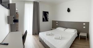 ein Schlafzimmer mit einem Bett mit zwei weißen Handtüchern darauf in der Unterkunft City Gallery Apartments in Triest