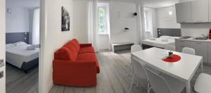 ein Wohnzimmer und eine Küche mit einem roten Stuhl und einem Tisch in der Unterkunft City Gallery Apartments in Triest