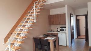 a kitchen with a wooden spiral staircase in a room at Végvár Delux apartman in Gyula