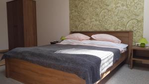 a bedroom with a bed with pink pillows on it at Végvár Delux apartman in Gyula