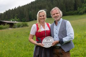 un hombre y una mujer de pie en un campo sosteniendo un premio en Hotel Landhaus Marchfeld, en Oberau