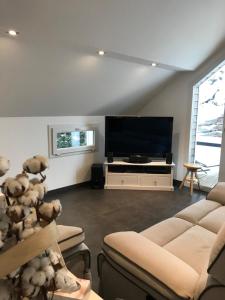 a living room with a large flat screen tv at Le Grand Sapin. Maison au calme proche commerces in Gérardmer