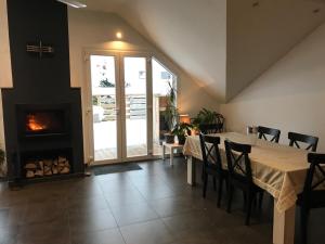 a dining room with a table and a fireplace at Le Grand Sapin. Maison au calme proche commerces in Gérardmer