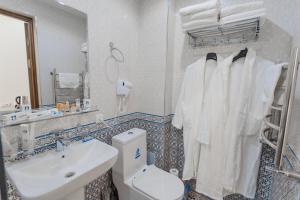 a bathroom with a sink and a toilet and towels at Guest House Diyor Gold in Samarkand