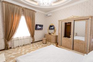 una camera con letto e specchio di Guest House Diyor Gold a Samarkand