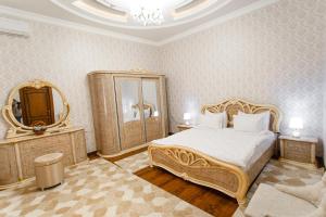 una camera con un grande letto e uno specchio di Guest House Diyor Gold a Samarkand